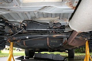 evaporative charcoal canister on a 2001 Toyota Sienna is located under a plastic shield